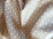 White dots on cream fabric